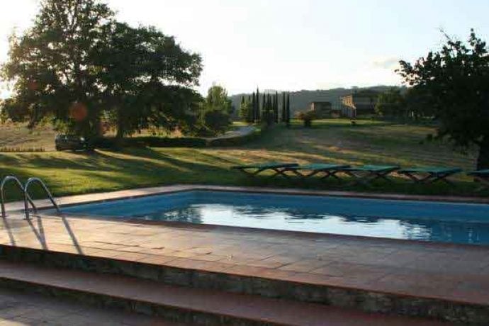 Sunny outdoor area and pool of villa Arezzo in Tuscany.