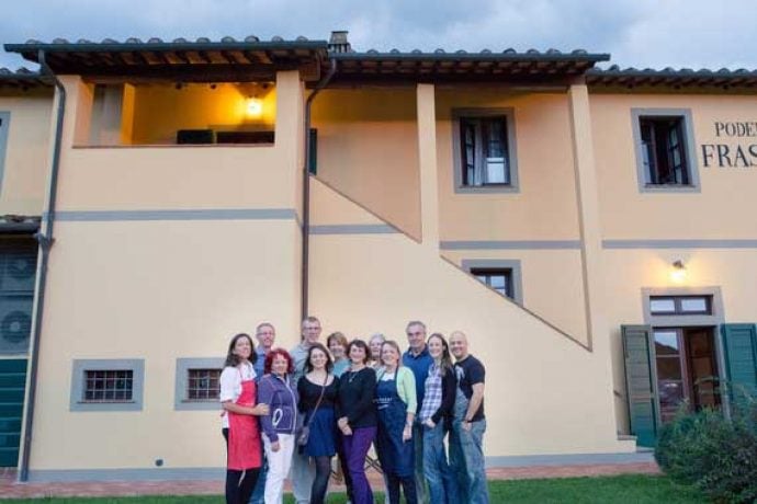 Group of single travellers with Italian chef in front of venue