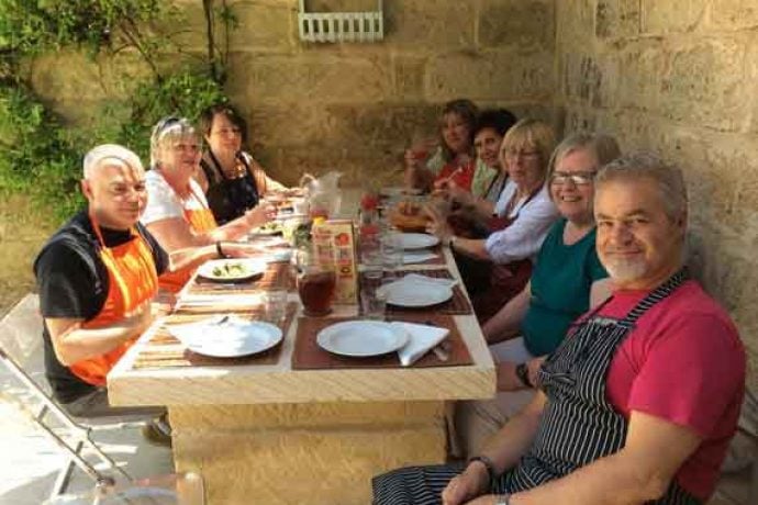 Group of guests enjoying meal outside.