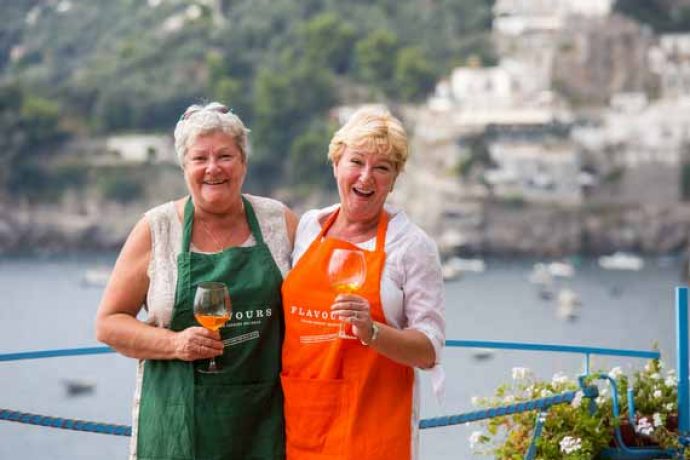 Two guests with aprons enjoying a glass of wine