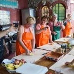 Cooking guests and teacher cheering with a glass of Italian wine