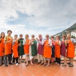 Group of cooking guests with aprons enjoying Amalfi outside