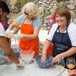 cooking guests having a cooking class outside learning how to make pizza