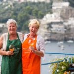 Women on cooking holiday laughing and enjoying glass of Prosecco