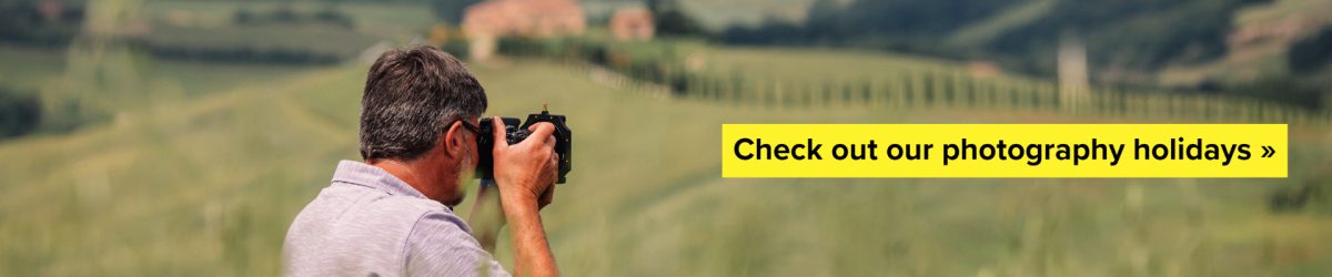Man with camera clicking photos in a Tuscany farm and villa