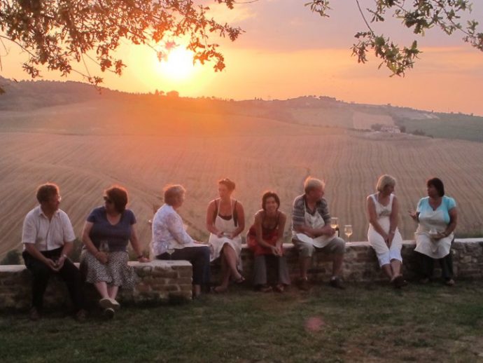 Solo travellers enjoying a glass of wine and sunset together